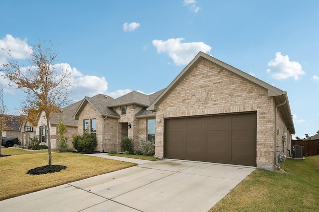 view of front of house with a garage, central AC, and a front yard