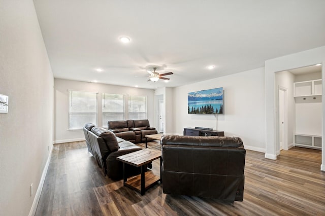 living room with ceiling fan and dark wood-type flooring