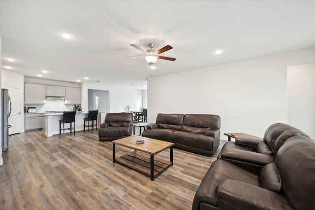 living room with ceiling fan and light hardwood / wood-style flooring