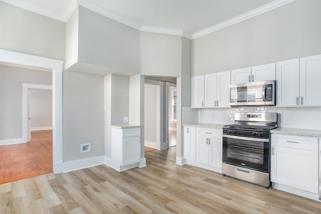 kitchen featuring a high ceiling, white cabinets, and appliances with stainless steel finishes