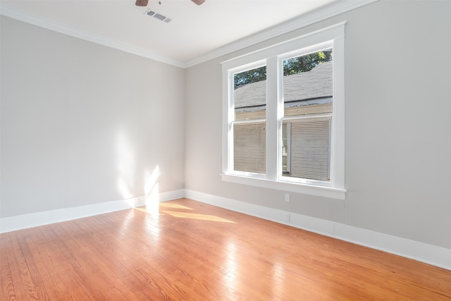 empty room featuring ceiling fan, light wood-type flooring, and crown molding