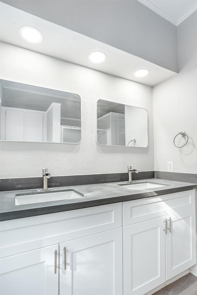 bathroom featuring hardwood / wood-style floors, vanity, and ornamental molding