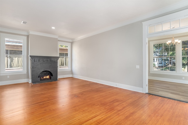 unfurnished living room featuring a fireplace, wood-type flooring, and a healthy amount of sunlight