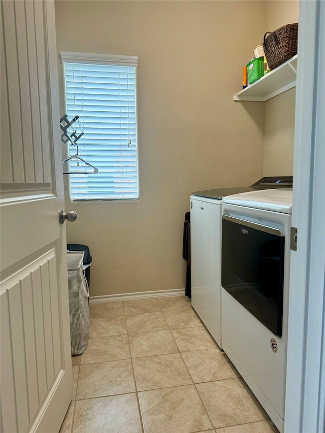 clothes washing area featuring light tile patterned floors and washer and clothes dryer