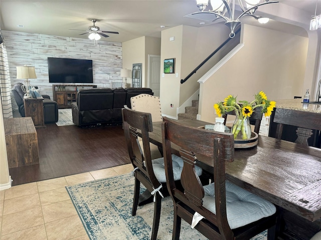 tiled dining space with ceiling fan with notable chandelier