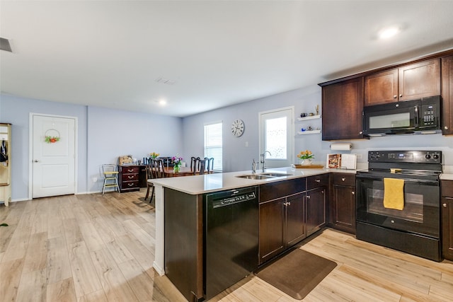 kitchen featuring black appliances, sink, light wood-type flooring, dark brown cabinets, and kitchen peninsula