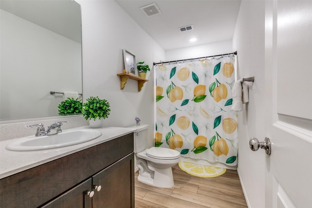 bathroom with hardwood / wood-style flooring, vanity, a shower with curtain, and toilet