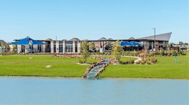 surrounding community featuring a water view and a lawn