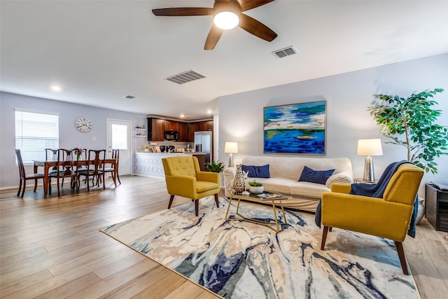 living room with light hardwood / wood-style flooring and ceiling fan