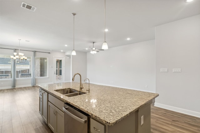 kitchen featuring sink, hanging light fixtures, stainless steel dishwasher, and an island with sink