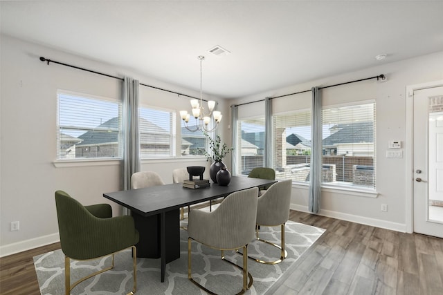 dining area featuring hardwood / wood-style floors and a notable chandelier