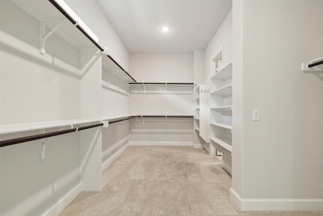 walk in closet featuring light colored carpet