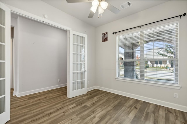 empty room with french doors, ceiling fan, and dark hardwood / wood-style floors