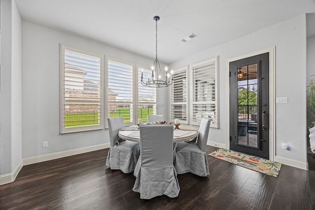 dining space featuring dark wood-type flooring and a notable chandelier