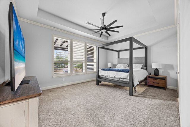 bedroom with a tray ceiling, ceiling fan, carpet flooring, and crown molding