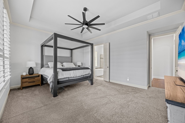 bedroom featuring crown molding, ensuite bath, ceiling fan, a tray ceiling, and carpet floors