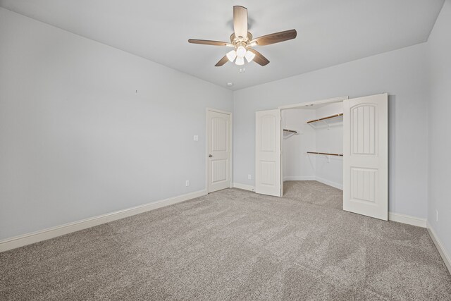 unfurnished bedroom with ceiling fan, a walk in closet, light carpet, and a closet