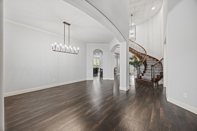 foyer entrance with crown molding, dark wood-type flooring, and a chandelier