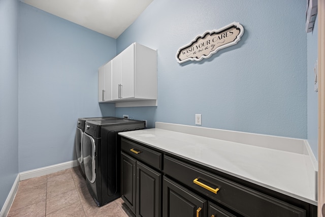 laundry room featuring separate washer and dryer, light tile patterned floors, and cabinets