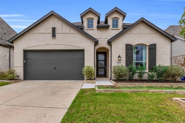 french country inspired facade featuring a front yard and a garage