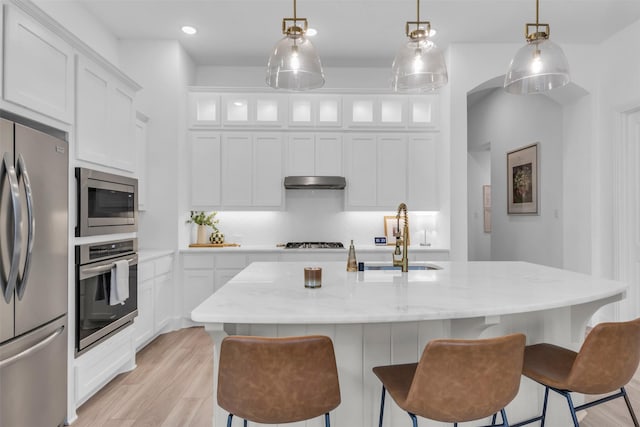 kitchen featuring white cabinetry, sink, stainless steel appliances, and light hardwood / wood-style floors