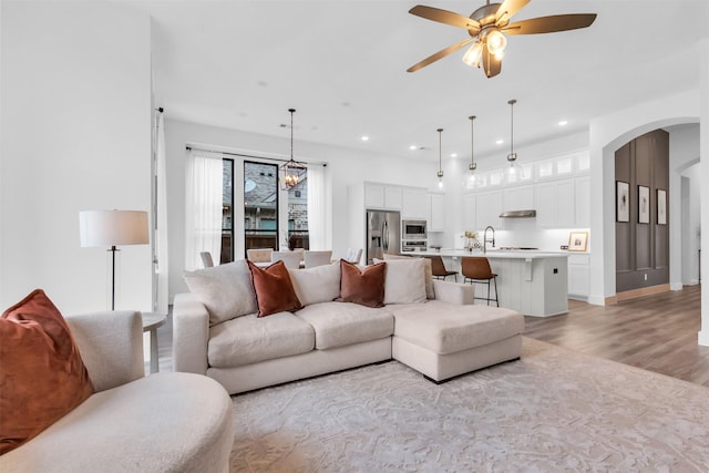 living room featuring ceiling fan, light hardwood / wood-style flooring, and sink