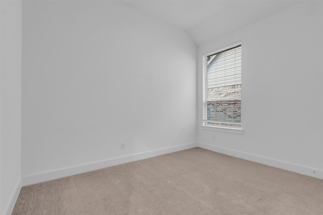 carpeted spare room featuring lofted ceiling