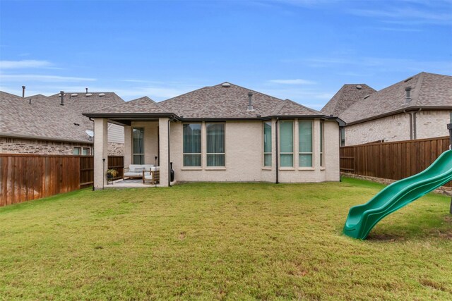 back of house featuring a playground, a yard, and a patio