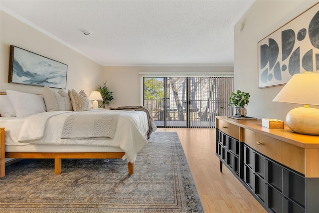 bedroom featuring hardwood / wood-style floors, a textured ceiling, and access to outside