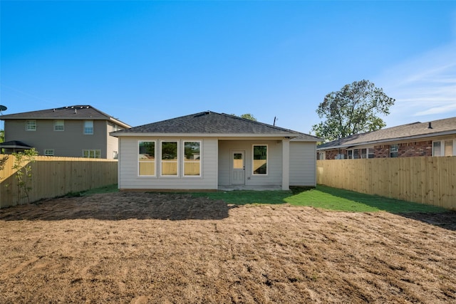 rear view of house featuring a yard