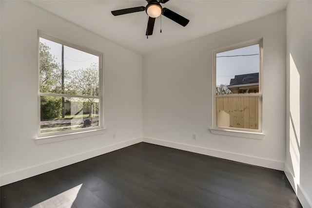 empty room featuring dark wood-type flooring and ceiling fan