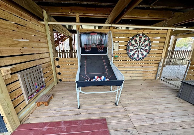 recreation room with beam ceiling, wood-type flooring, and wooden walls