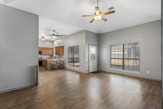 unfurnished living room with sink, a high ceiling, and dark hardwood / wood-style floors