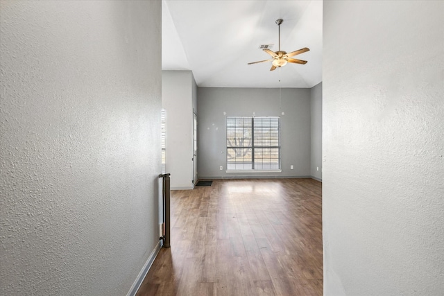 unfurnished room with ceiling fan, wood-type flooring, and high vaulted ceiling