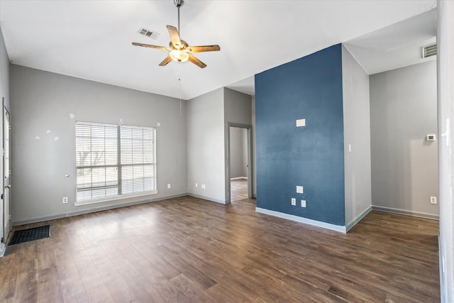 spare room with dark hardwood / wood-style flooring, vaulted ceiling, and ceiling fan