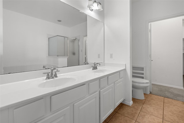 bathroom featuring tile patterned floors, vanity, toilet, and an enclosed shower