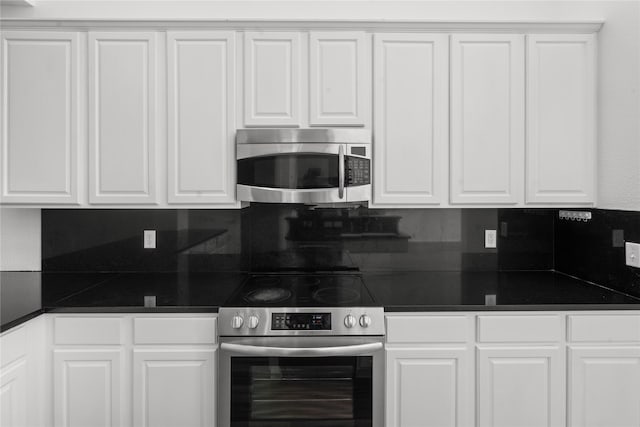 kitchen featuring white cabinets, decorative backsplash, and stainless steel appliances