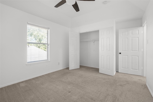 unfurnished bedroom featuring ceiling fan, a closet, and light colored carpet