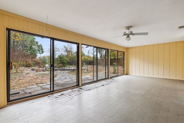 unfurnished sunroom with ceiling fan and plenty of natural light