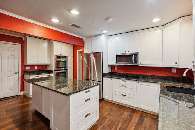 kitchen featuring dark hardwood / wood-style floors, dark stone countertops, sink, and stainless steel appliances