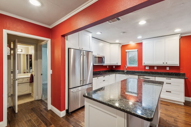 kitchen featuring white cabinetry, a center island, dark hardwood / wood-style flooring, appliances with stainless steel finishes, and ornamental molding