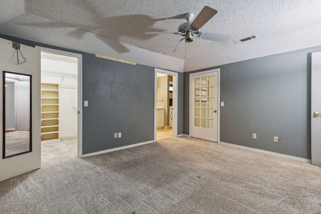 carpeted empty room featuring ceiling fan and a textured ceiling