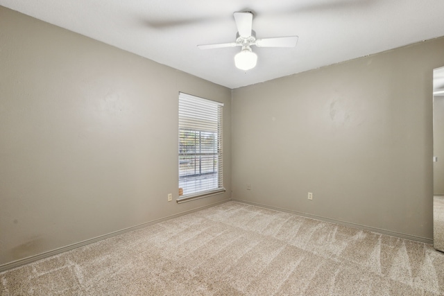 empty room featuring ceiling fan and light colored carpet