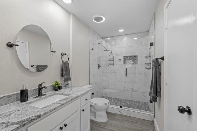 bathroom with vanity, toilet, a shower with shower door, and wood-type flooring