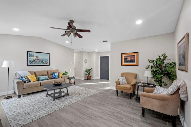 living room featuring ceiling fan, lofted ceiling, and light wood-type flooring