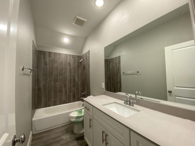 full bathroom with hardwood / wood-style floors, lofted ceiling, toilet, vanity, and tiled shower / bath