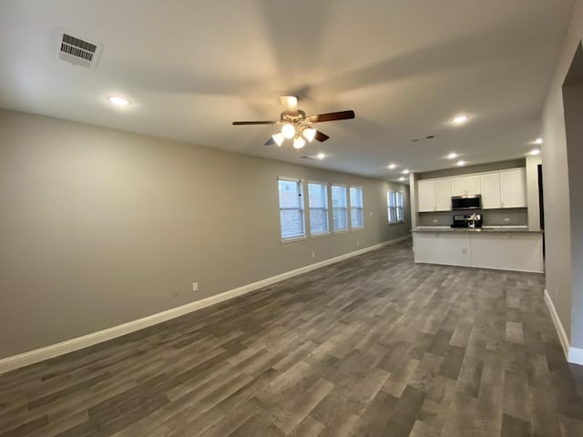 unfurnished living room with ceiling fan and dark hardwood / wood-style flooring