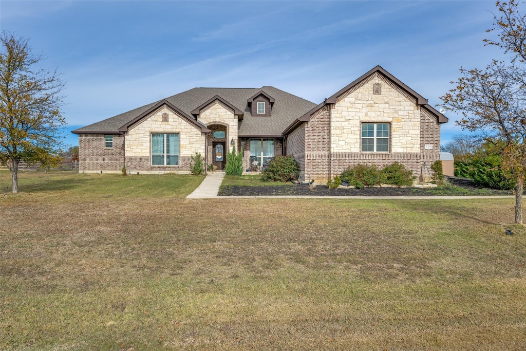 french country inspired facade with a front yard