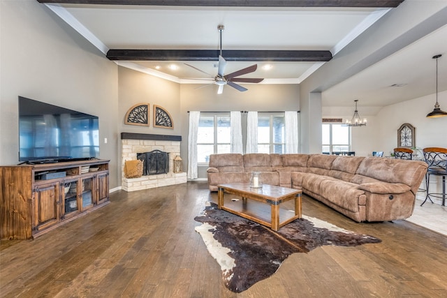 living room featuring ceiling fan with notable chandelier, a stone fireplace, crown molding, beamed ceiling, and dark hardwood / wood-style flooring