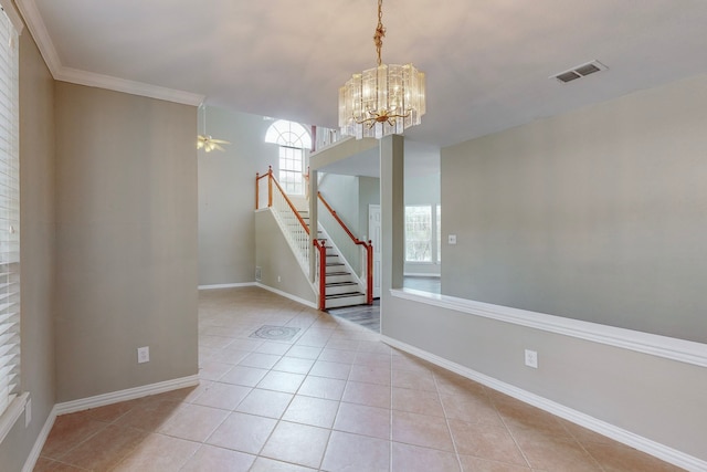 tiled spare room featuring ceiling fan with notable chandelier and ornamental molding